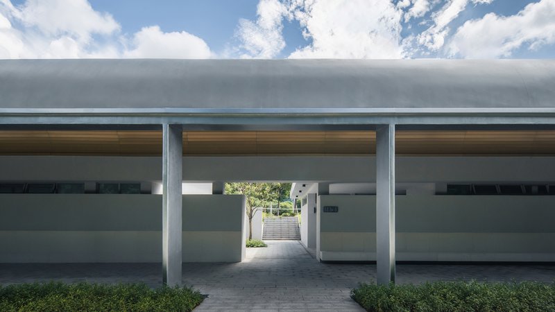 Central passage beneath three concrete barrel vaults with timber soffit panels and clerestory glazing