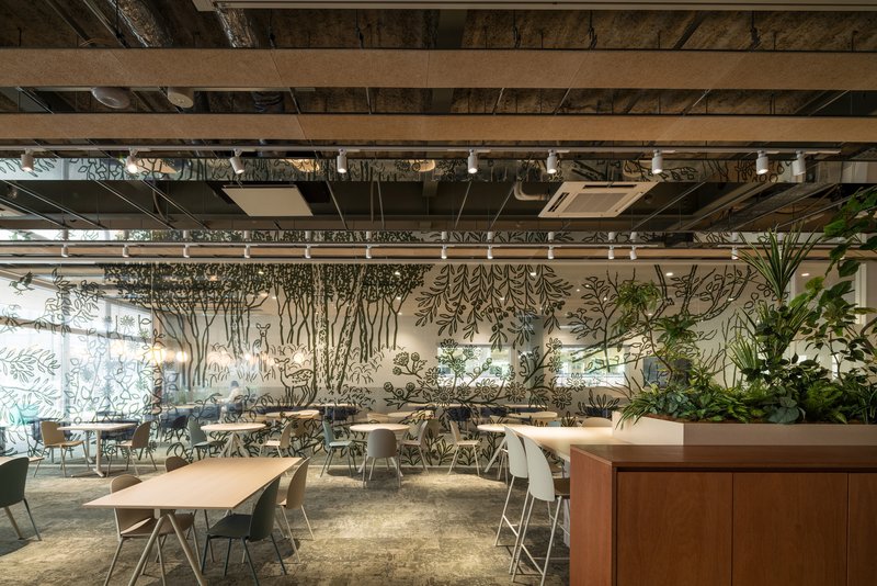 Dining area with hand-painted tree mural on the rear wall and hanging plants suspended from the exposed structure