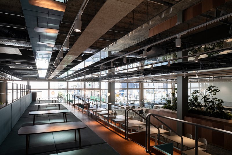 Tiered seating area with metal handrails and warm uplighting along the steps near floor-to-ceiling windows