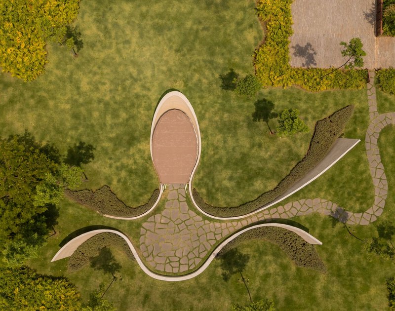 Overhead view of the oval pavilion with stone paving branches radiating into the surrounding lawn and planting beds