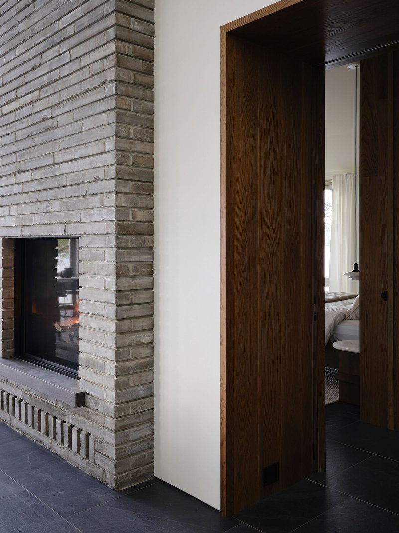 Horizontal brick fireplace surround beside doorway with oak frame and sliding door