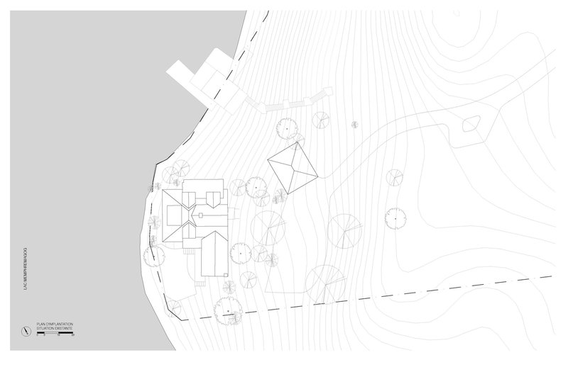 Site plan drawing showing a residence with separate outbuilding surrounded by trees on a lakeside plot