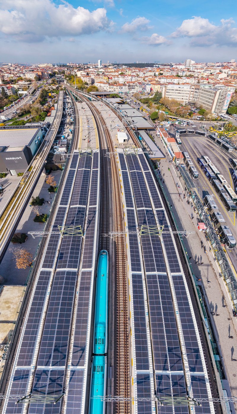 Drone view of platform canopies covered with photovoltaic panels spanning railway tracks below