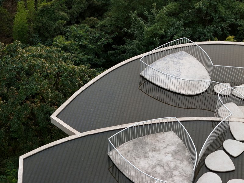 Aerial view of two curved roof terraces with white metal railings and petal-shaped decks