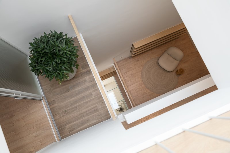 Aerial view showing timber platforms at different levels connected by white walls and a potted plant