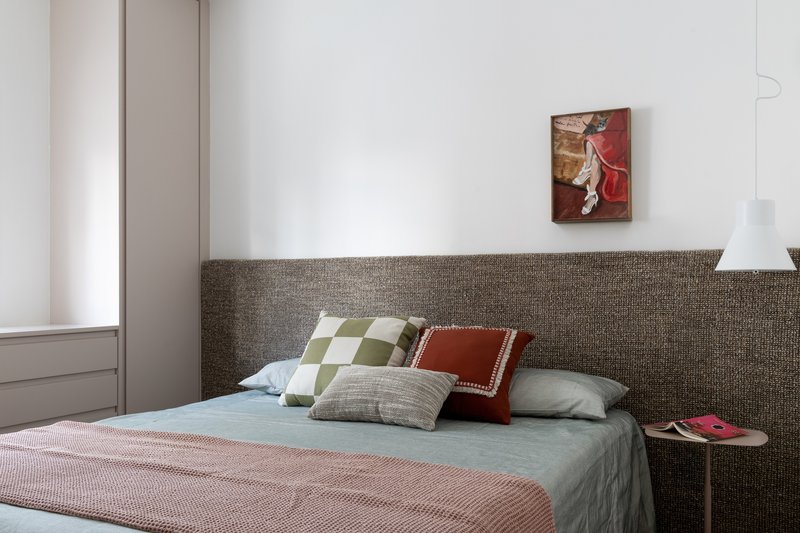 Bedroom with textured headboard wall and pendant light beside the bed