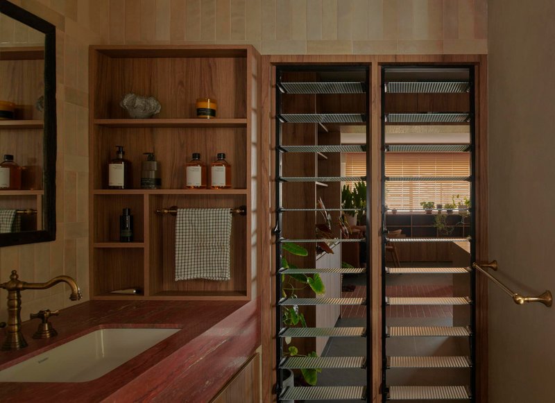 Open shelving unit revealing a glass-doored refrigerator with wire racks and hanging plants