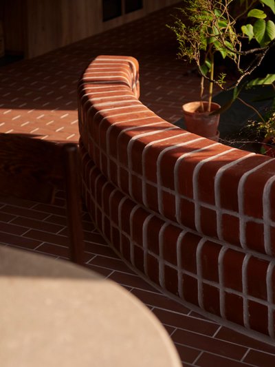 This architectural image showcases a curved brick wall, likely part of an outdoor space such as a co