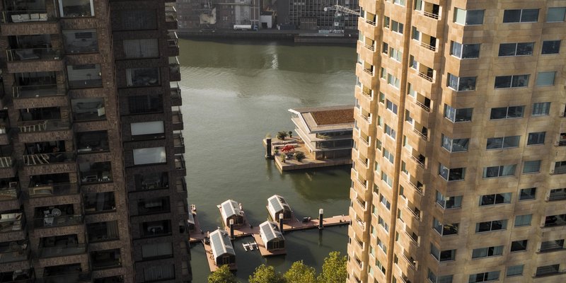 Aerial view of the floating pavilions moored between residential towers in the waterway