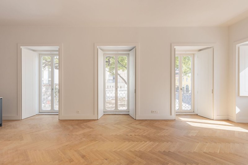 Three deep-set windows with splayed reveals overlooking tree-lined street and herringbone flooring