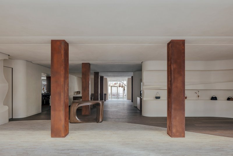 Long view through the shop interior showing a sequence of steel columns flanking the central axis