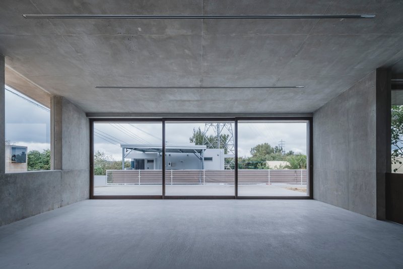 Upper level interior with panoramic sliding glass doors overlooking rooftop terrace and neighboring buildings