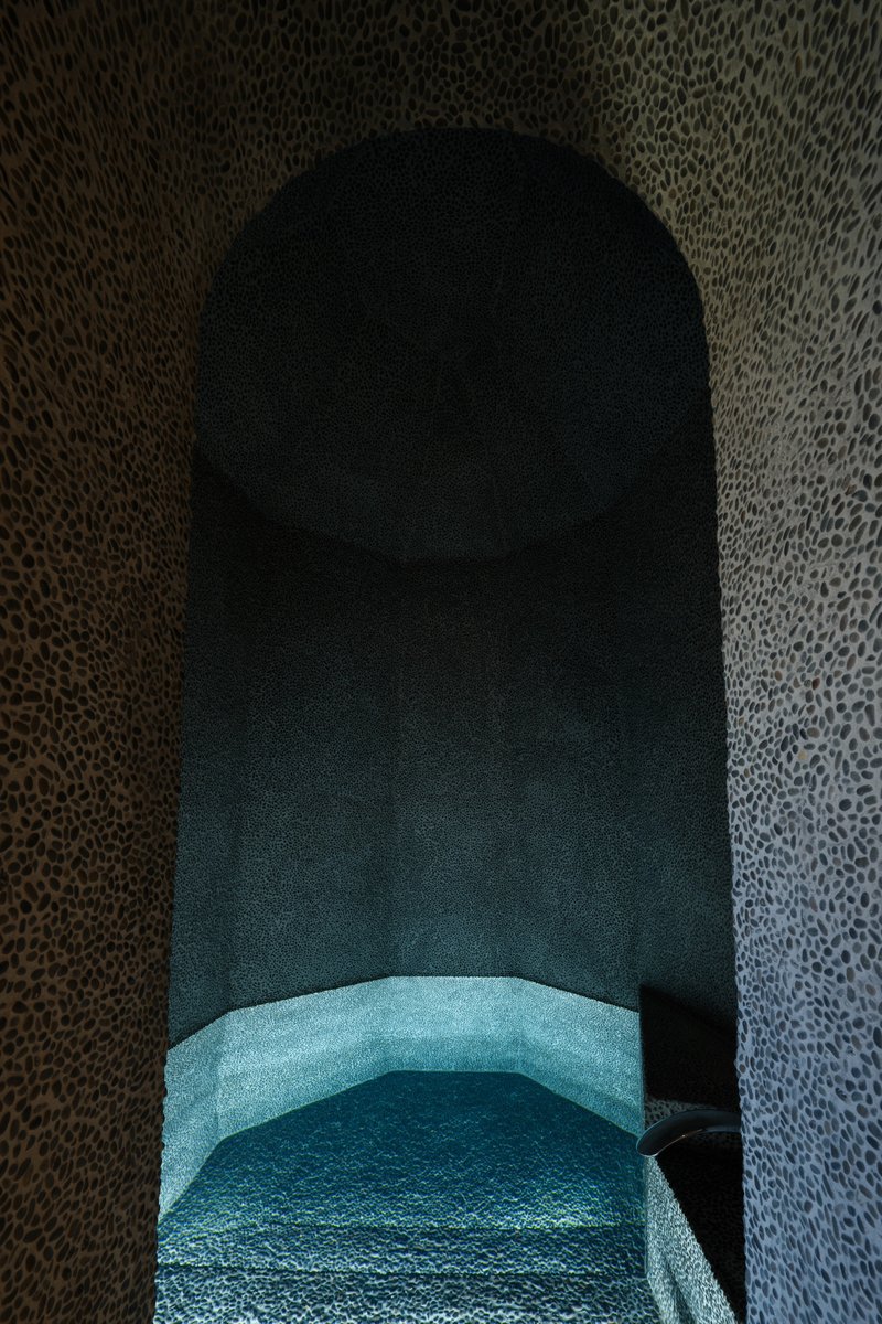 Close-up inside the vaulted stone niche showing the curved turquoise bench seat