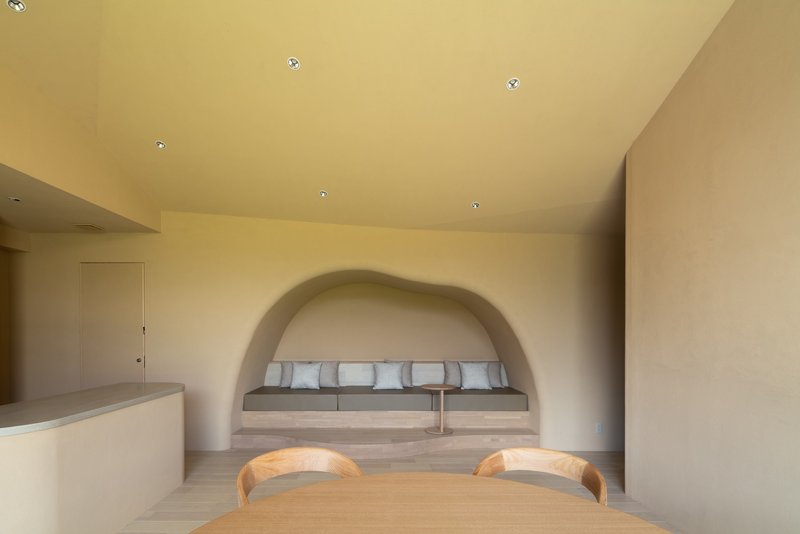 Interior view of dining area with built-in bench beneath a plastered arched alcove
