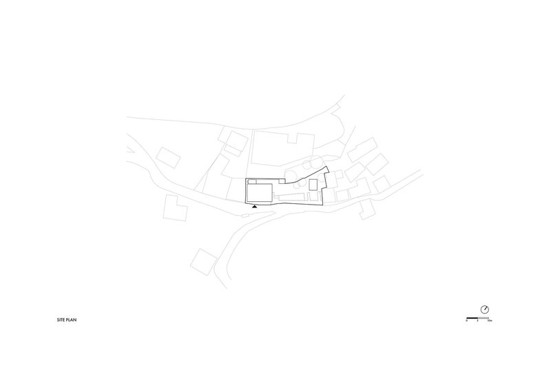 Site plan drawing showing building footprint among adjacent structures and curving site roads