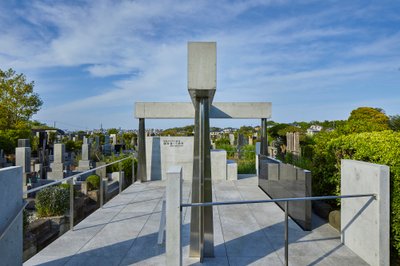 This architectural image showcases a modern memorial site within a cemetery. The design features a c