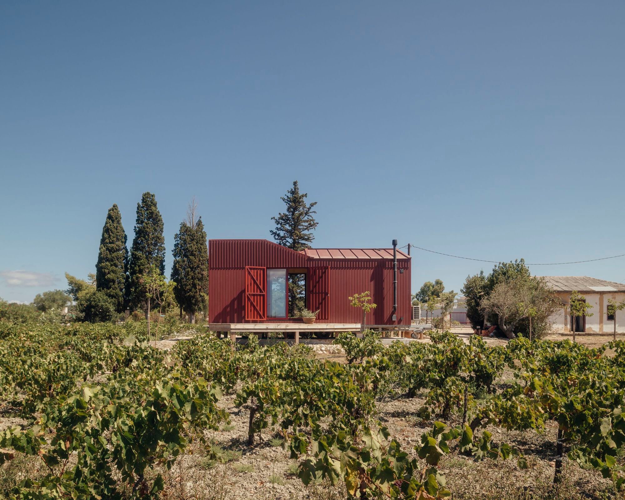 Kasawoo Plants a Deep Red Timber Cabin in a Family Vineyard on Zakynthos