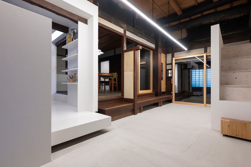 Interior hallway with white partition walls contrasting dark timber framing and exposed ceiling beams