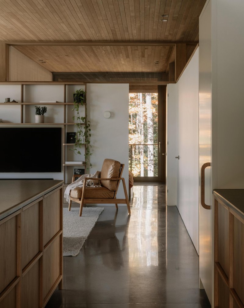 Hallway with polished concrete floor leading to seating area under coffered ceiling