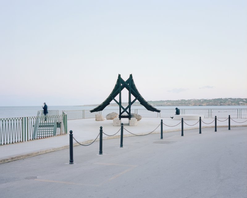 Rear view of the timber structure with A-frame supports on a plaza by the sea