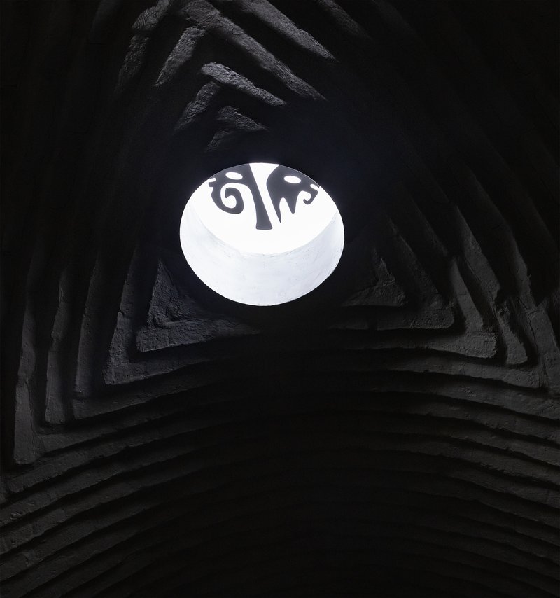 Upward view into pyramidal shaft with circular skylight opening above