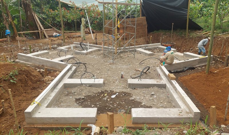Foundation layout with concrete beams radiating from center under construction canopy
