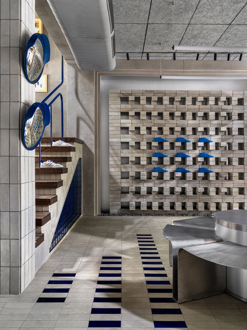 Overhead view showing spiral stair, protruding block wall, and linear floor pattern connecting retail spaces