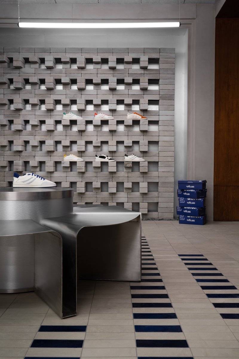 Three-dimensional masonry wall with projecting blocks forming display shelves under linear fluorescent light fixture