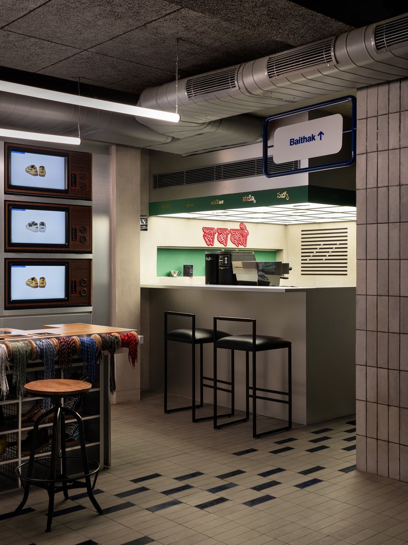Service counter with illuminated menu panels and exposed ductwork running beneath textured ceiling tiles