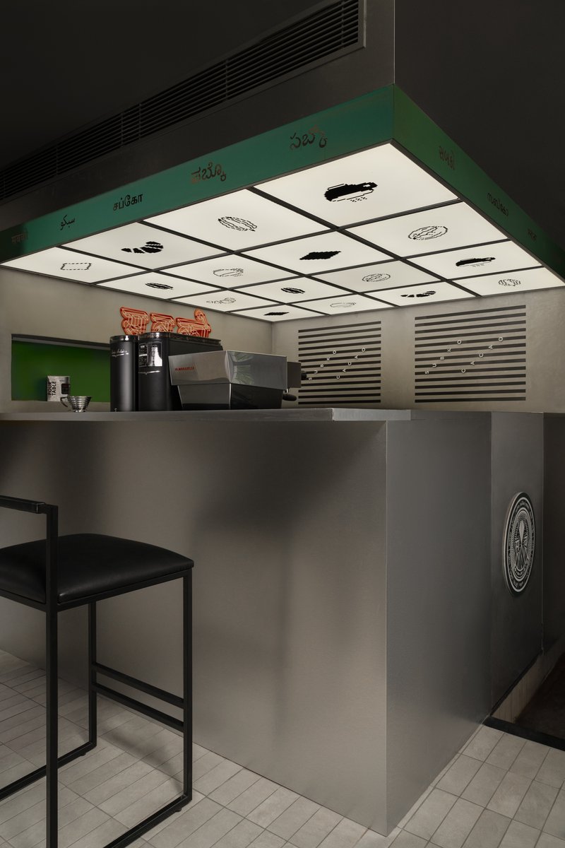 Close-up of counter canopy with backlit grid panels showing food illustrations above service area