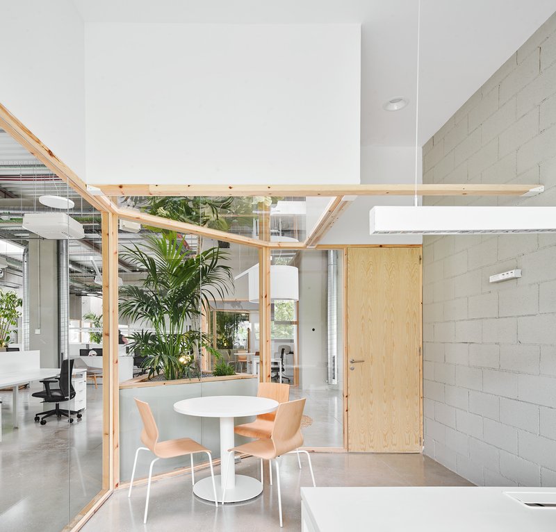 Corner meeting nook framed in timber with glass walls and a painted masonry block wall