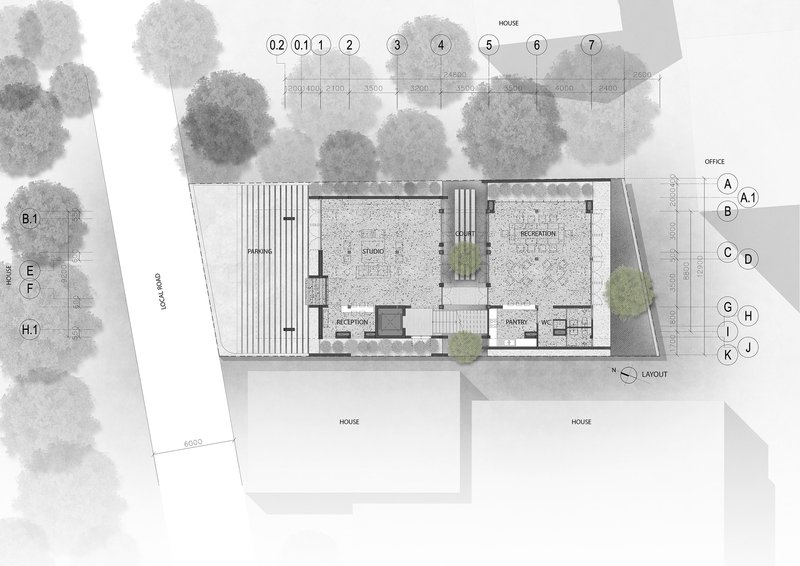 Site plan drawing showing building footprint with central courtyard and surrounding trees