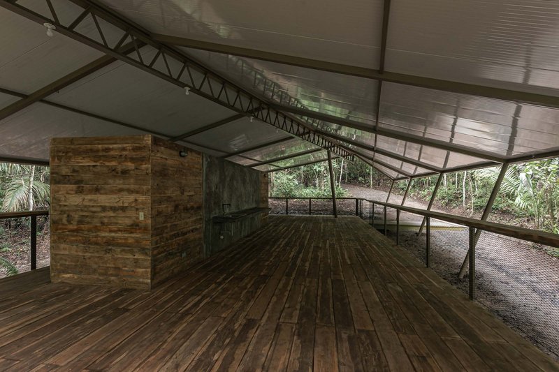 Interior deck with reclaimed wood flooring, timber service core, and exposed steel trusses under translucent panels