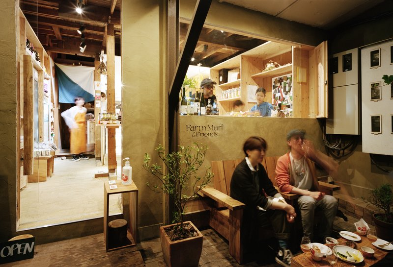 Exposed timber beams and rafters above a seating area with service window and product shelving in background