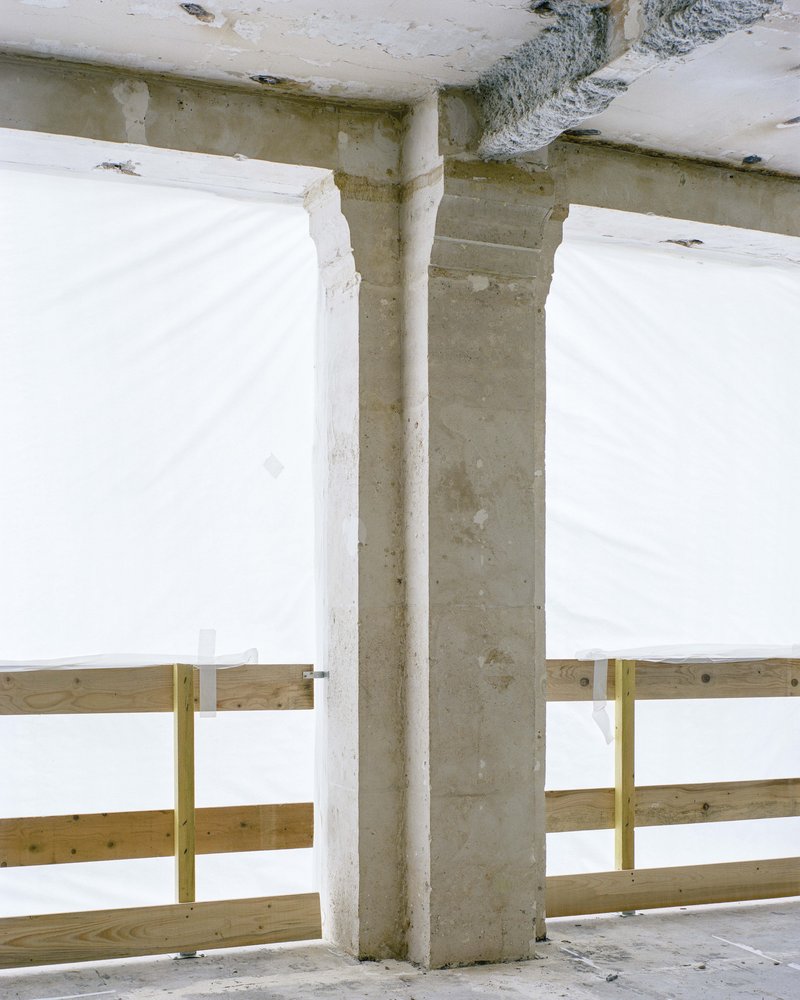 Close-up of concrete beam and column junction with temporary timber guardrail in construction