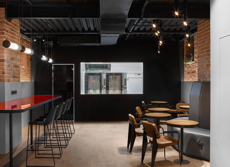 Dark dining zone with exposed brick and controlled lighting