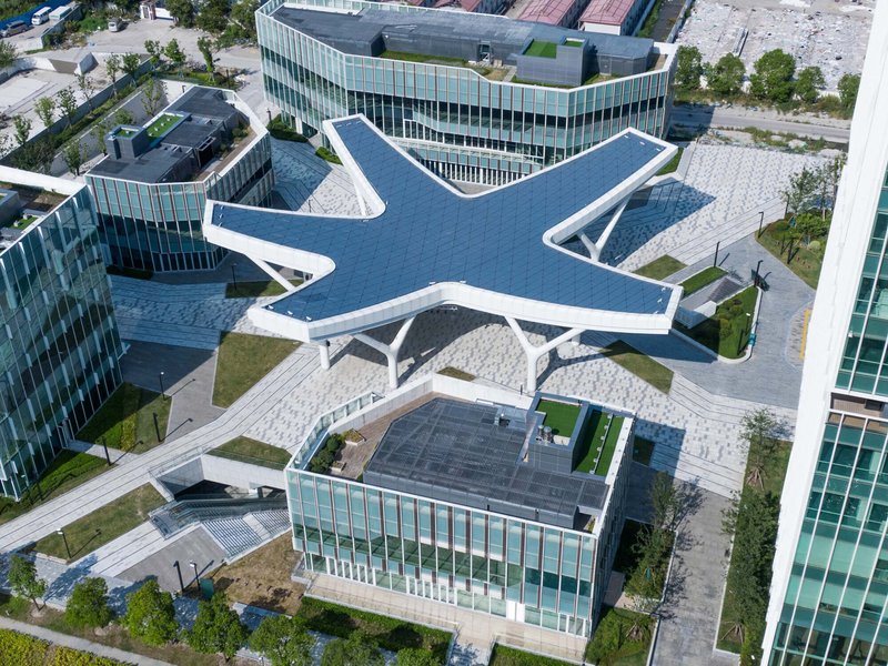Drone view of the white steel canopy with six radiating arms above a paved plaza