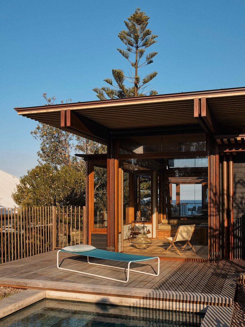 Poolside deck with timber louvered screens and wide eaves in late afternoon sunlight