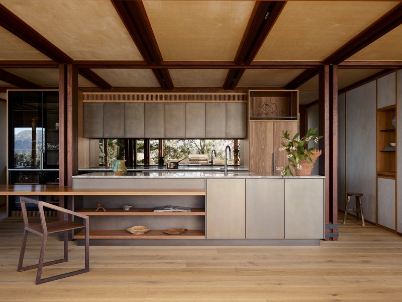 Kitchen island with pale cabinetry and timber frame structure beneath flat ceiling panels