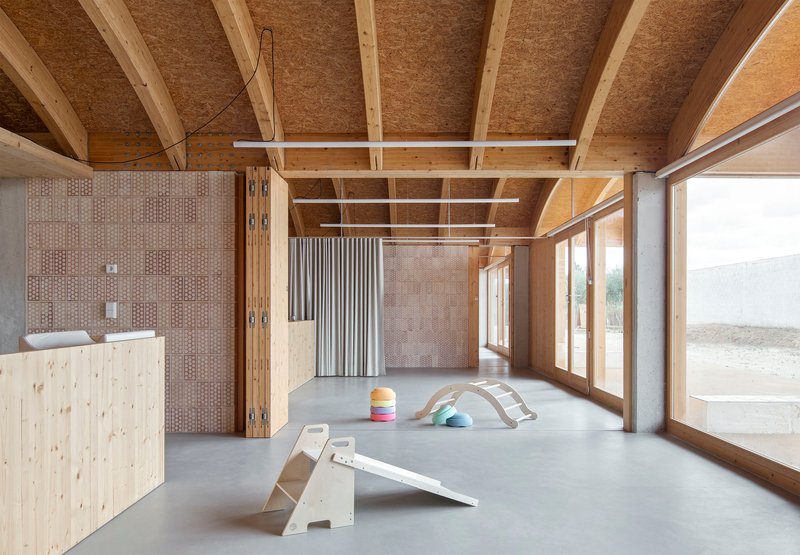 Interior with exposed timber ceiling beams and tiled wall panels dividing the polished concrete floor