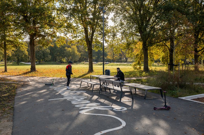 Ping pong table on a curved paved court with tree shadows in autumn
