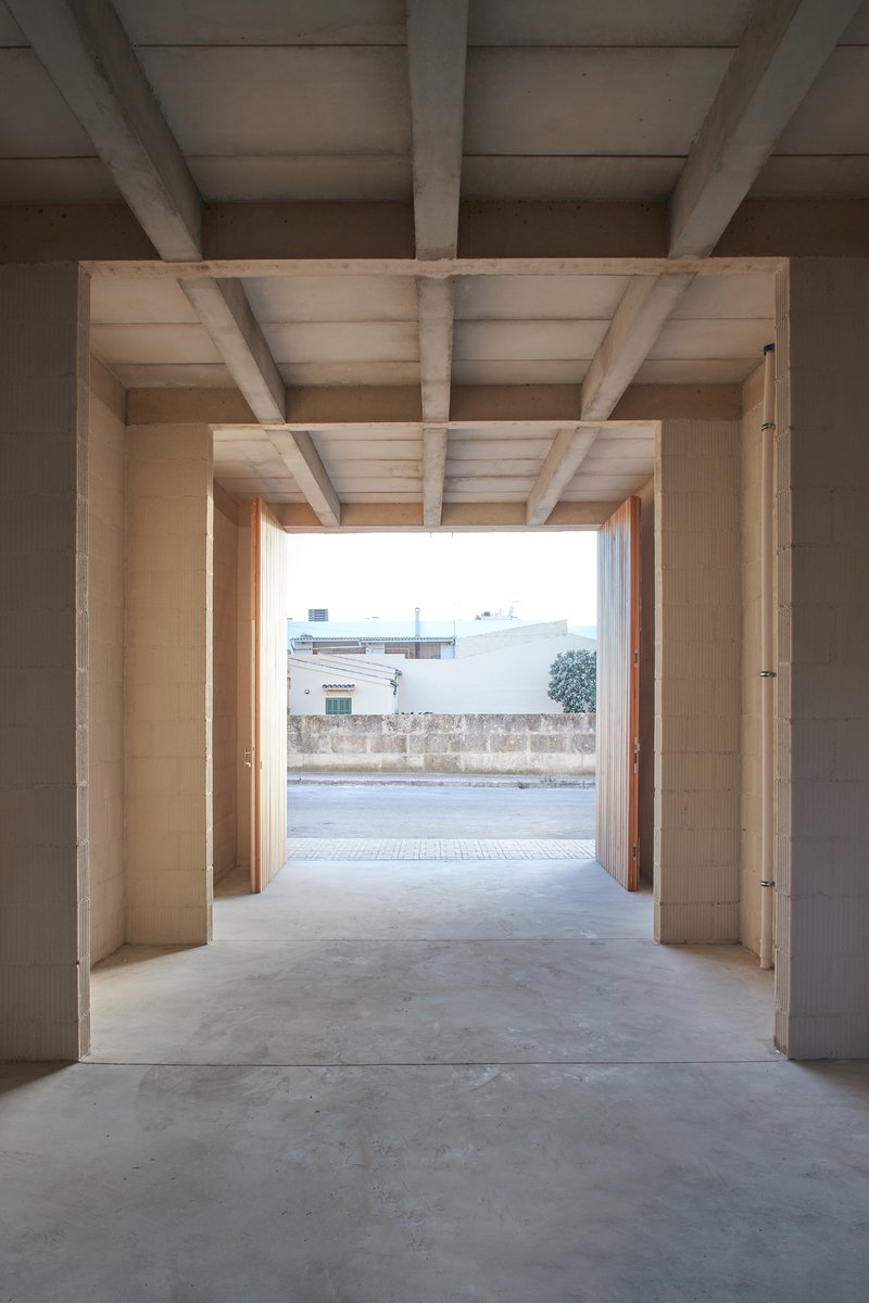 Entry passage framed by exposed timber beams and joists opening onto the street