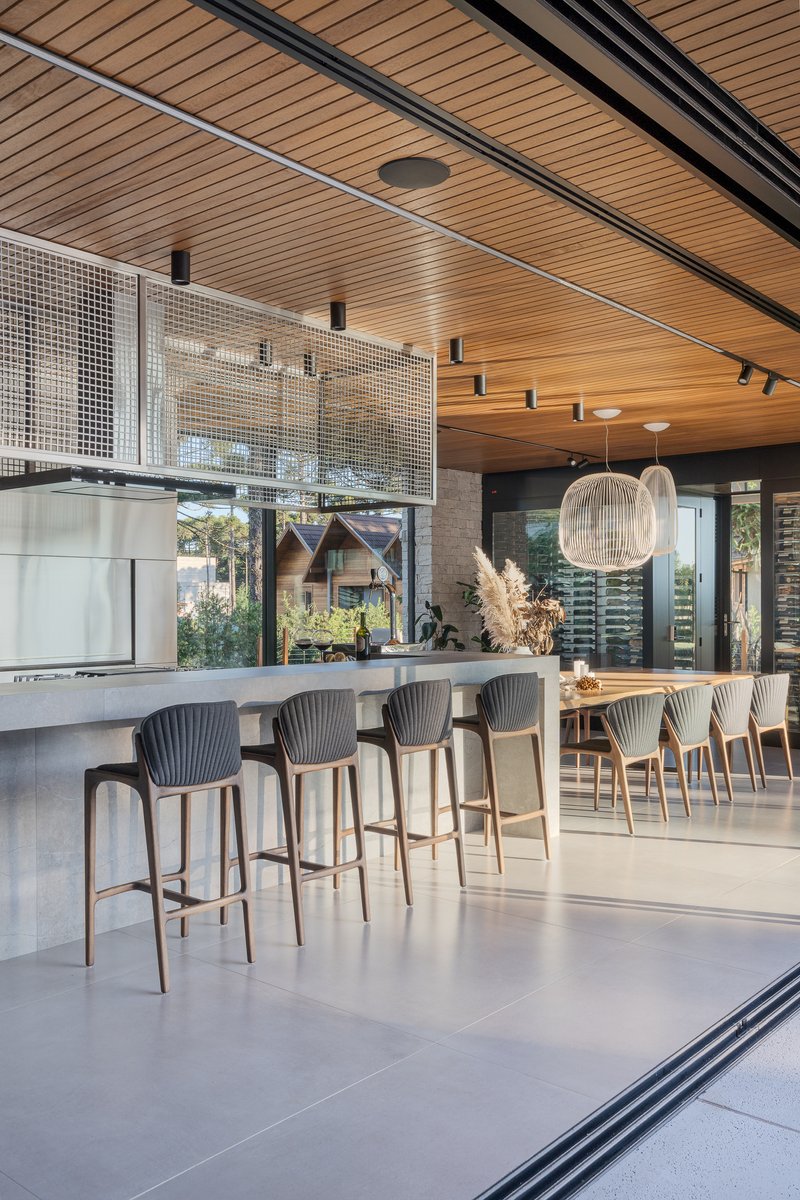 Kitchen island with bar seating beneath a slatted wood ceiling and black track rails