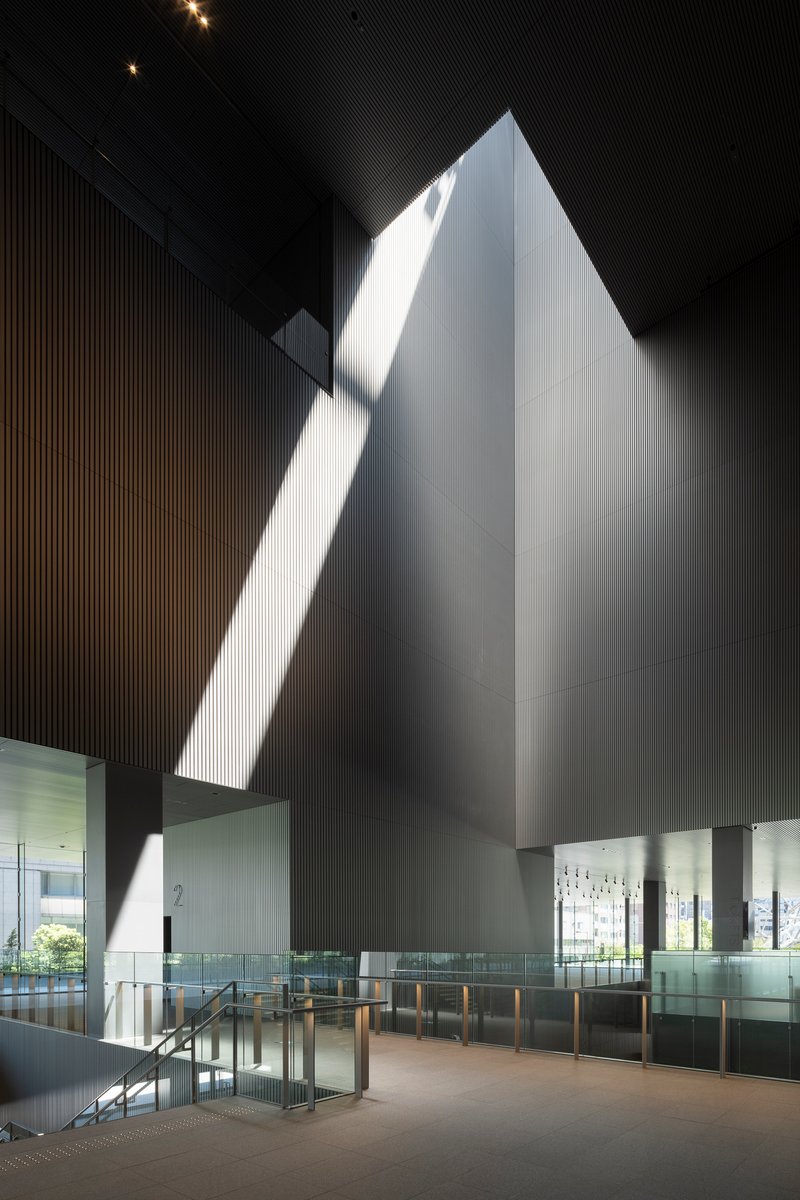 Tall pyramidal volume illuminated by dramatic daylight slicing through the dark ribbed ceiling