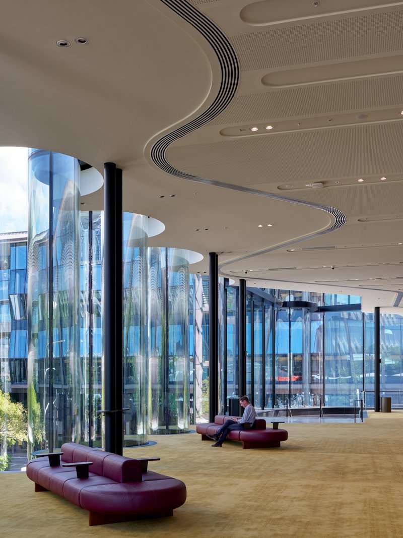 Interior showing the ribbed ceiling detail with circular light wells beside the glazed cylindrical facade columns