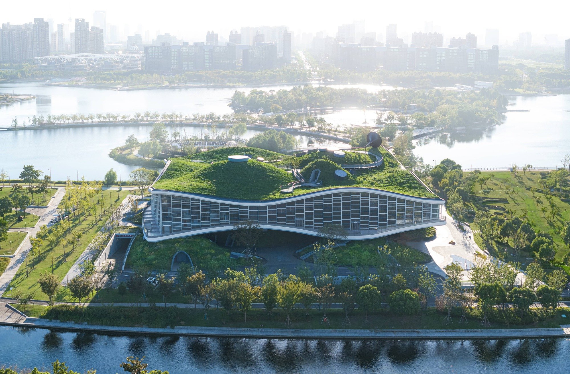Scenic Architecture Office Sculpts a Science Fiction Museum from Concrete Waves on a Shanghai Lake