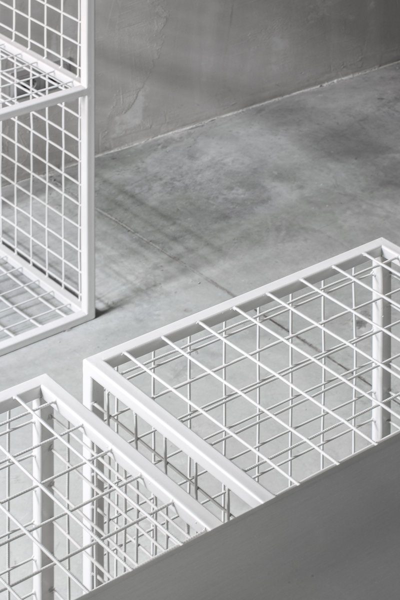 Close-up of white steel grid display units highlighting material precision and texture.