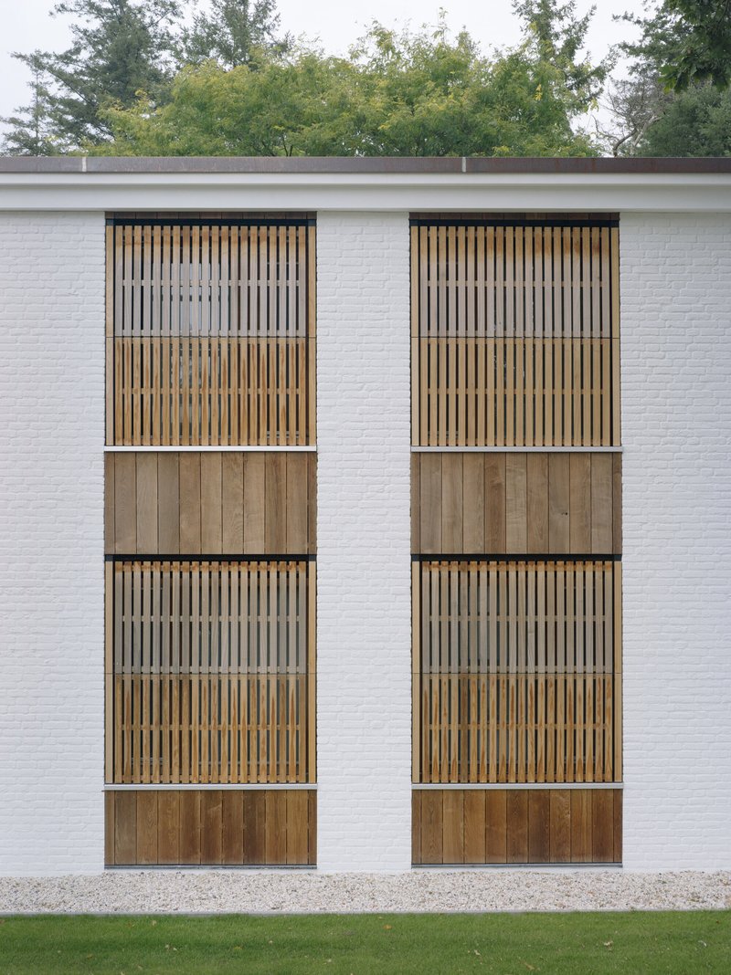 Close-up of paired timber balconies with vertical slat screens and solid panel bases