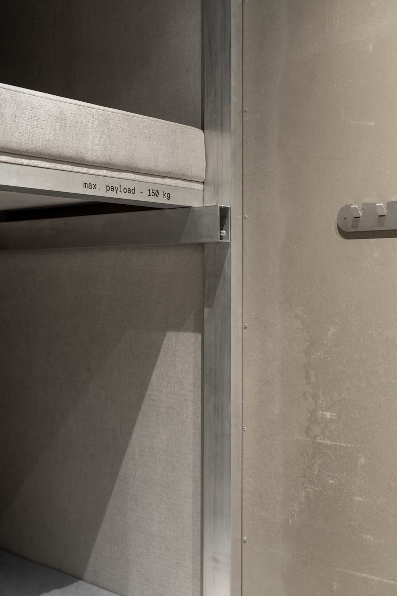 Industrial shelf unit with maximum payload label against concrete wall with exposed fasteners