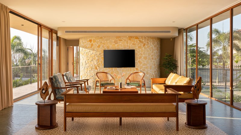 Living room featuring a textured stone accent wall with floor-to-ceiling glazing on both sides